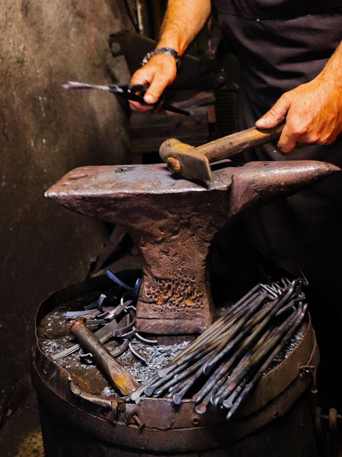 Blacksmith hand-forging a blade on an anvil